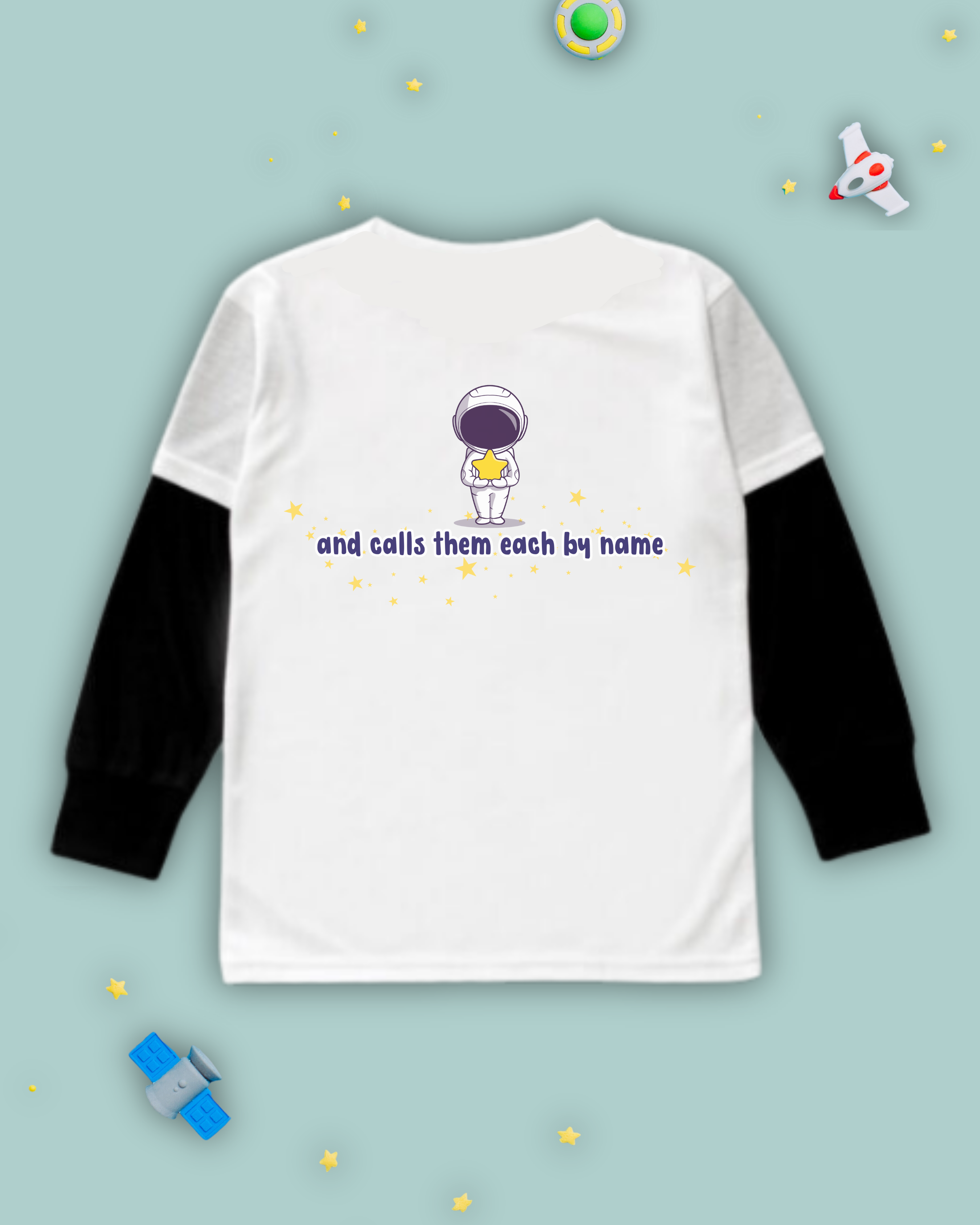 White kids Christian tshirt with black long sleeve undershirt decorated with an astronaut holding a star with the words "and calls them each by name" among stars beneath it. 