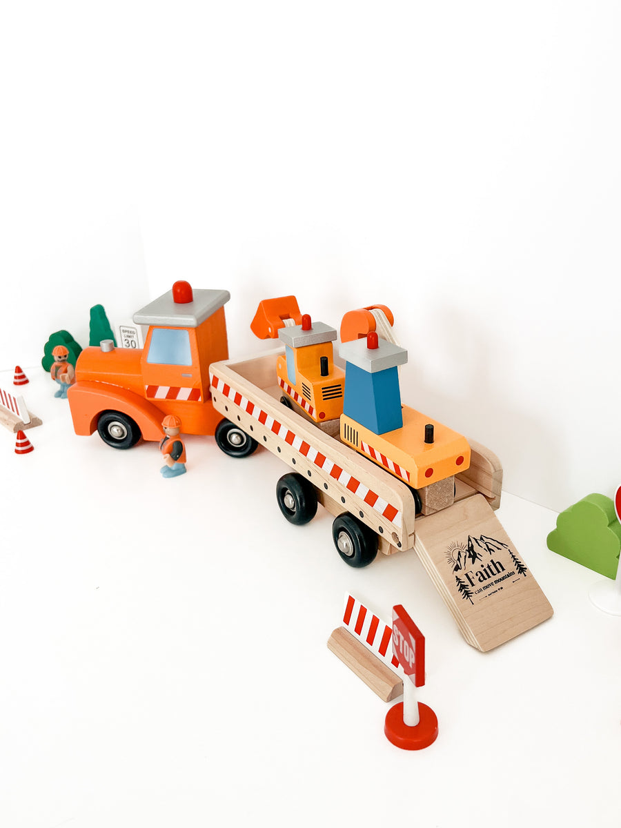 wooden toy trucks with the verse "faith can move mountains" printed on the ramp.