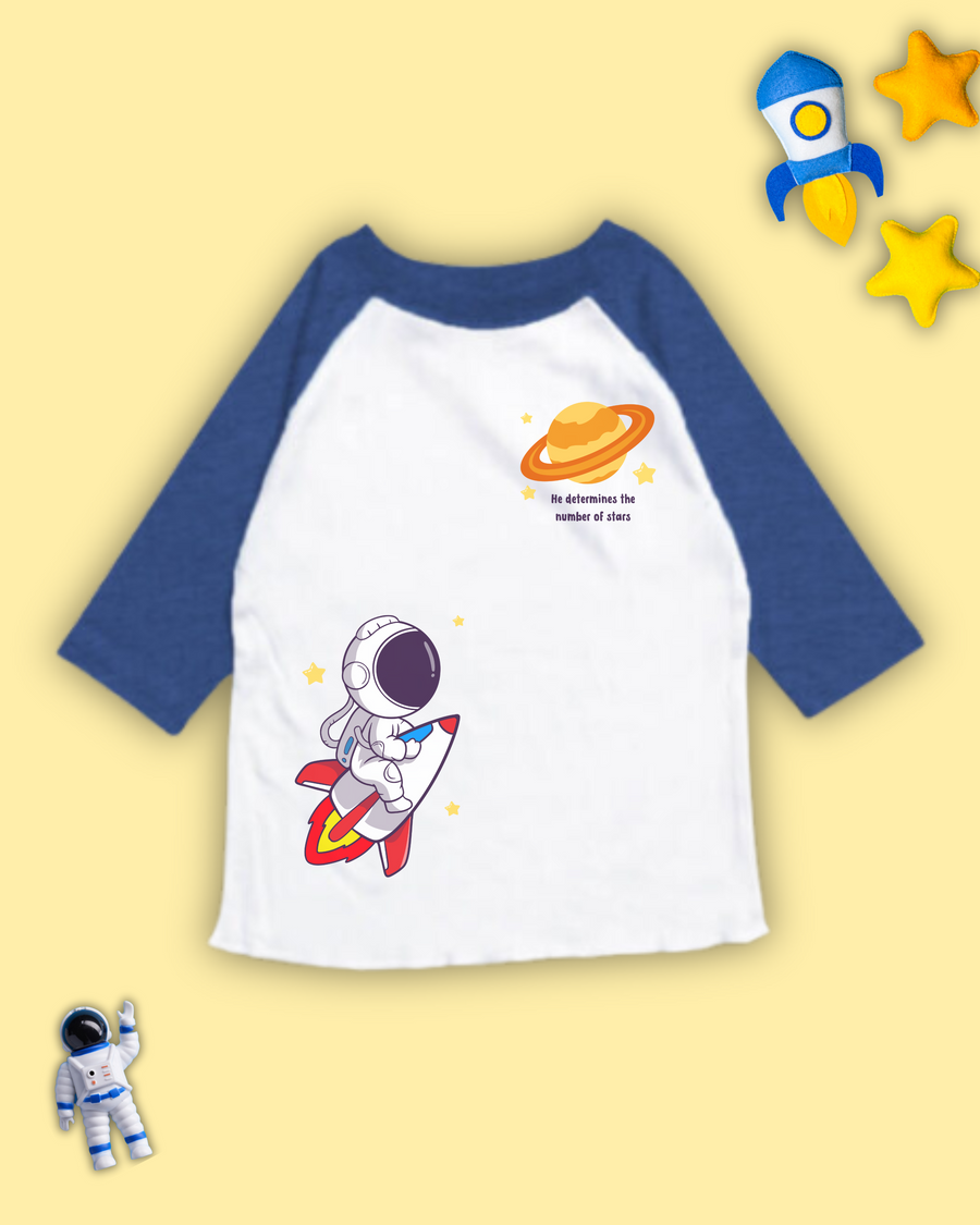 Blue and white christian raglan tshirts for kids that has an astronaut, rocketship, planet, stars and bible verse from Psalm 147