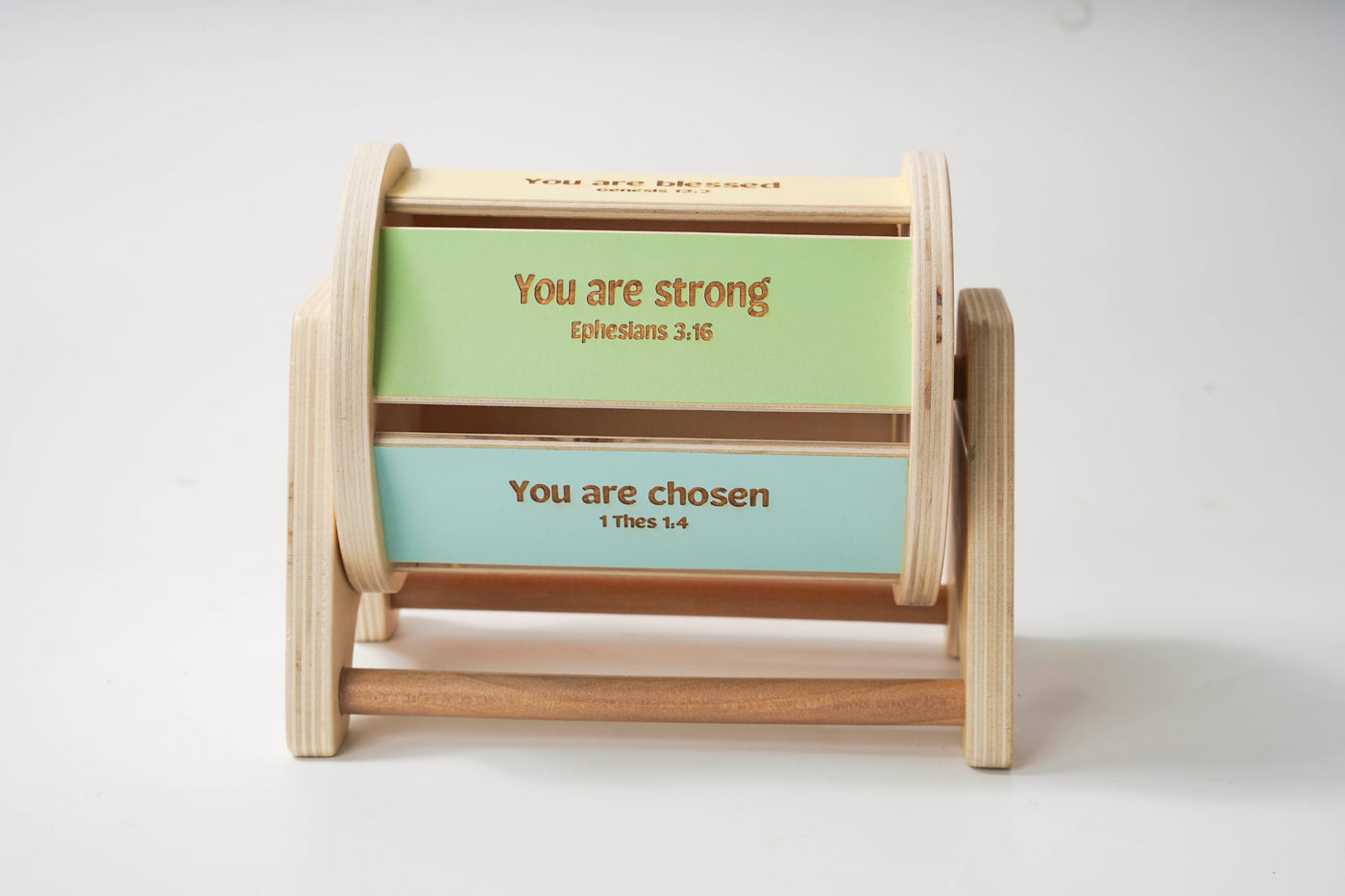 Colorful wooden spinning drum where each side of the drum features an affirmation bible verse.
